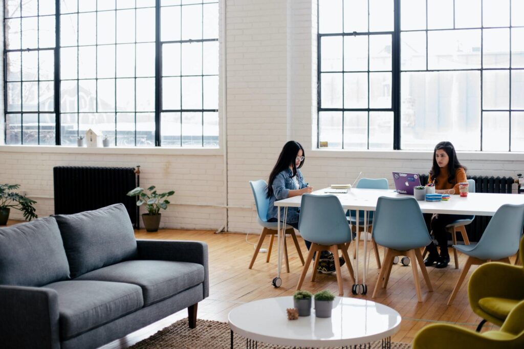 Two women working at a table in a coworking space