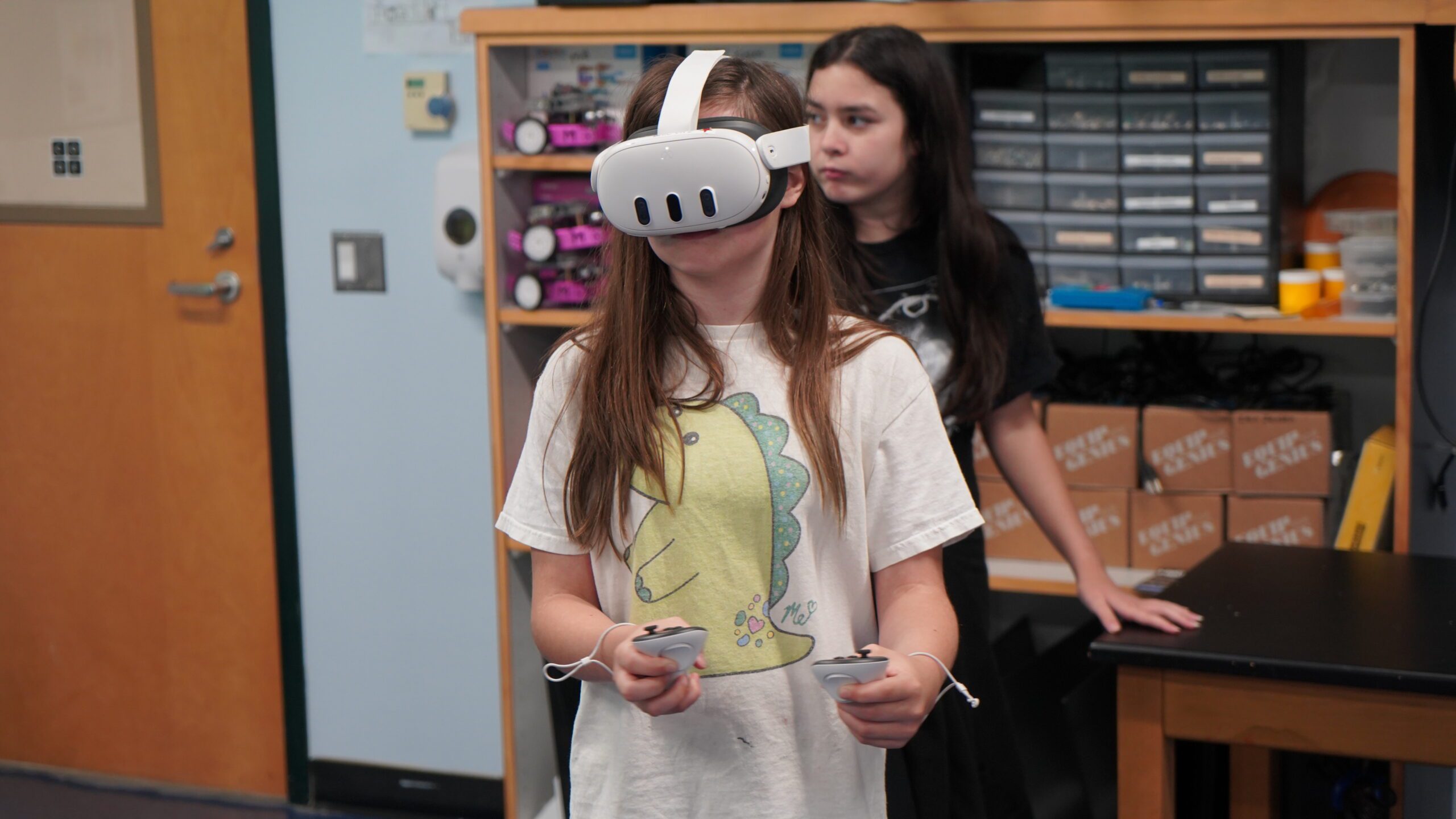 Middle School girl with brown hair wearing a Virtual Reality Headset and holding controllers