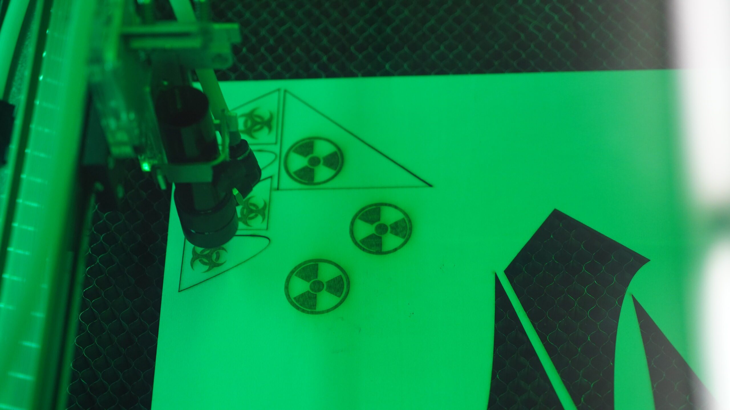BRIC's Laser Cutter cutting out images displayed in a green tint
